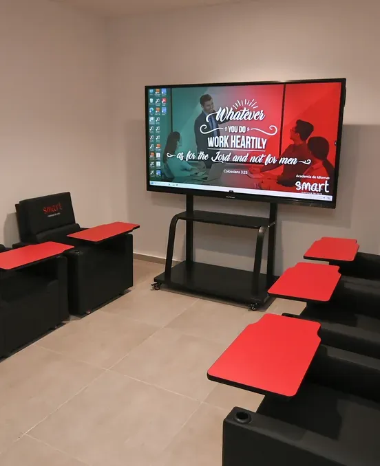 Aula con pupitres rojos y pantalla interactiva