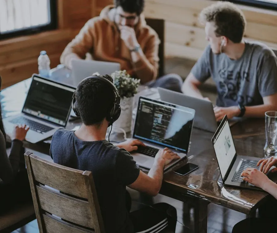 Equipo de trabajo colaborando con portátiles en una reunión de oficina